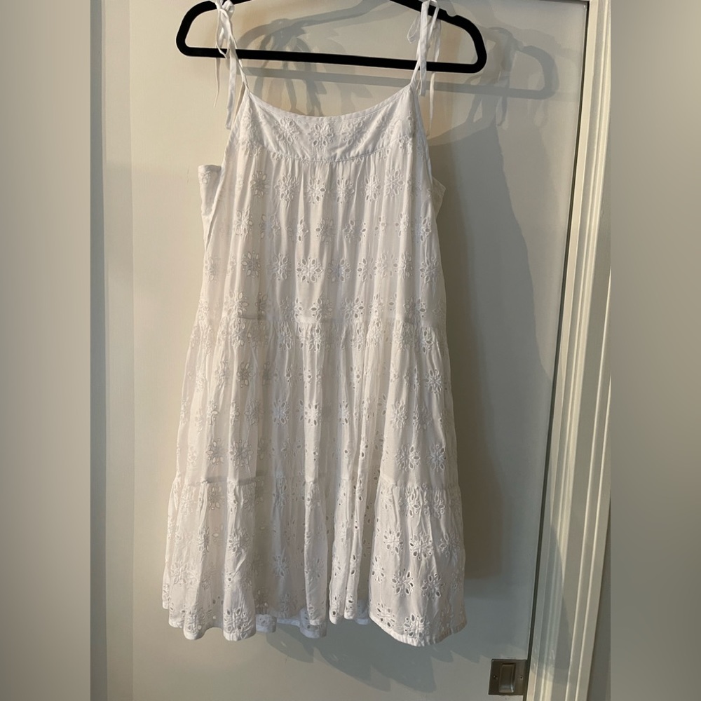 Eyelet dress with adjustable shoulder straps in white.